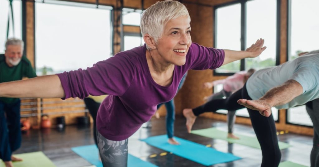 Kvinde igang med at lave en yoga-stilling for at afhjælpe stive led.